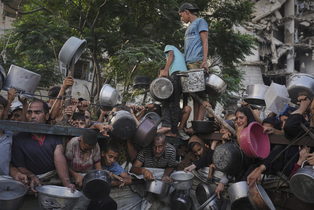 Palestinians struggle to get donated food at a community kitchen in Gaza City, northern Gaza Strip, July 14, 2025. 