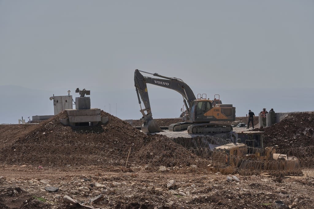 Workers stand beside a bulldozer at one of five new Israeli army positions built inside Lebanese territory along the road between Houla and Kfar Kila following airstrikes and a ground offensive that destroyed nearby villages, southern Lebanon, Wednesday, August 20, 2025. 