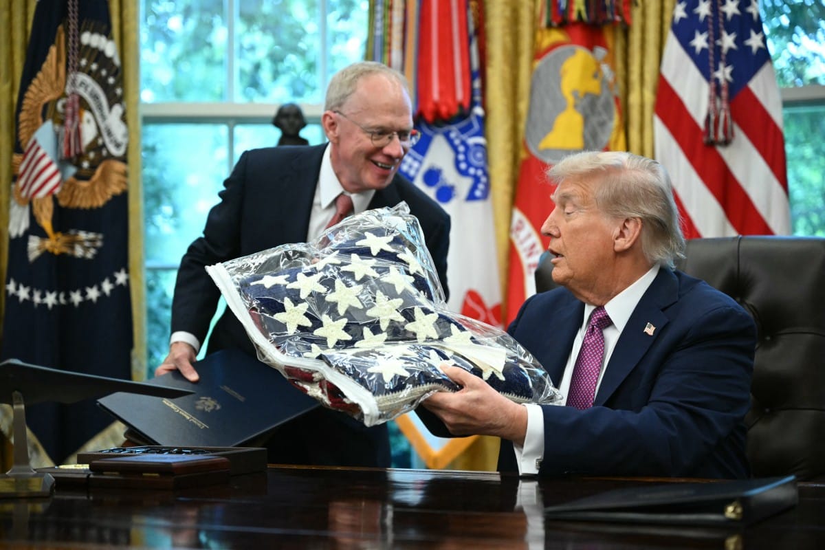 US President Donald Trump (R) receives a flag from US Representative John Rose, Republican of Tennessee, while signing executive orders in the Oval Office of the White House in Washington, DC on September 5, 2025.