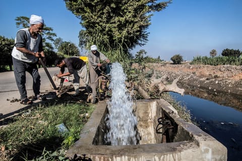 Egyptian farmer Mohamed Omar (L), 65, supplies his farmland with water from a canal, fed by the Nile river, in the village of Baharmis on the outskirts of Egypt's Giza province, northwest of the capital Cairo, on December 1, 2019.