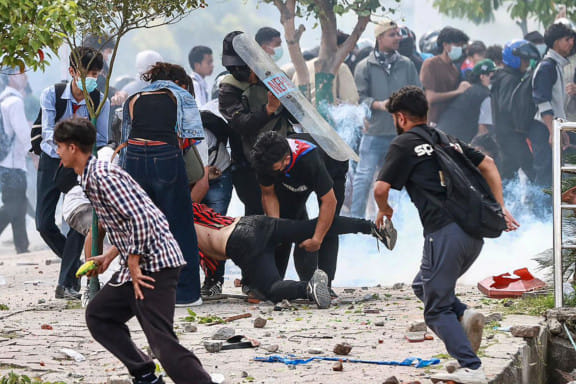 Demonstrators carry an injured victim during a protest outside the Parliament in Kathmandu on September 8, 2025, held to condemn the government over social media prohibitions and corruption.  