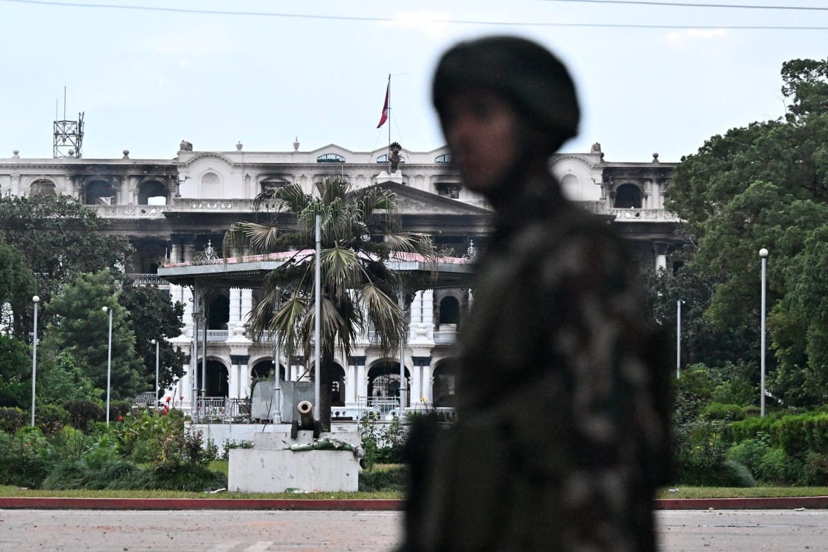 Army personnel stands guard near Singha Durbar, the main administrative building for the Nepal government, after it was set ablaze by protesters, in Kathmandu on September 12, 2025.