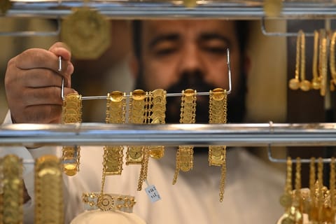 A Kuwaiti jeweller arranges gold items at his shop in downtown Kuwait City, on September 13, 2025.