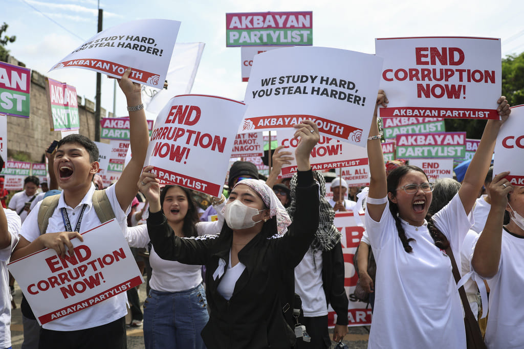 Protesters carry signs as they gather during a rally against government corruption at the EDSA People Power Monument in suburban Mandaluyong, east of Manila, Philippines, Sunday. Sept. 21, 2025. 