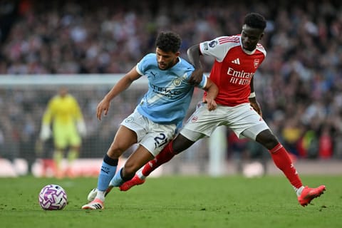 Manchester City's Portuguese midfielder Matheus Nunes (left) vies with Arsenal's English midfielder Bukayo Saka during the English Premier League football match at the Emirates Stadium in London on September 21, 2025.