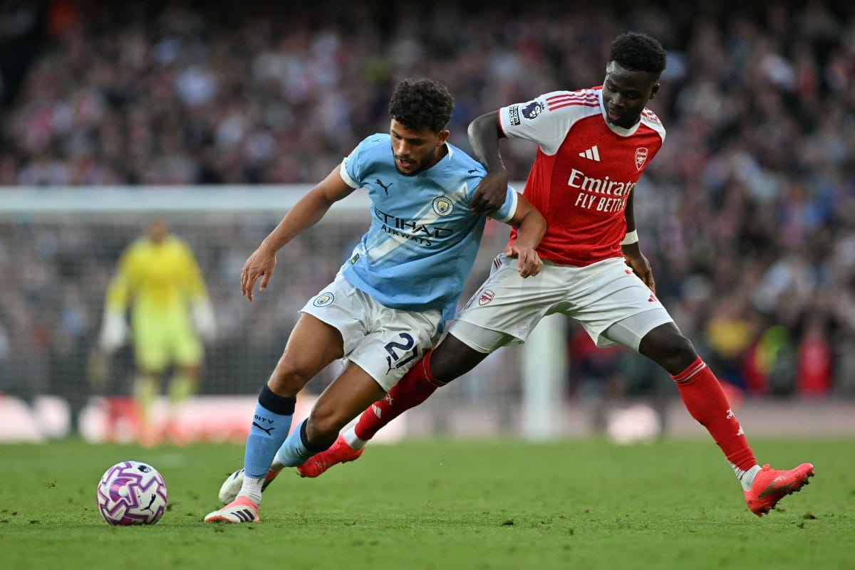 Manchester City's Portuguese midfielder Matheus Nunes (left) vies with Arsenal's English midfielder Bukayo Saka during the English Premier League football match at the Emirates Stadium in London on September 21, 2025.