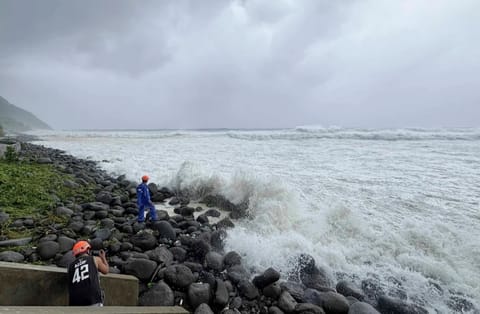 People watch as strong waves batter Basco, Batanes province, northern Philippines as Typhoon Ragasa affects the area on Monday, Sept. 22, 2025. 