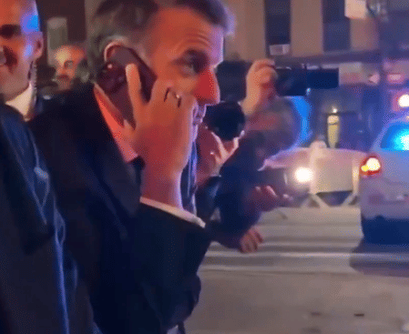 BFMTV footage shows Macron told police he couldn’t cross due to an incoming motorcade.