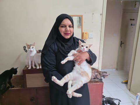 Aisha Rashid with some of her cats in the apartment dedicated to around 65 rescued cats. 