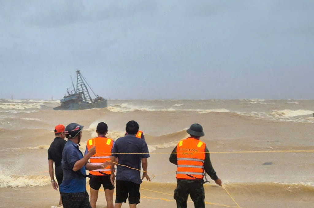 People work to rescue fishermen on a stranded fishing boat due to Typhoon Bualoi in Quang Tri, Vietnam Sunday, Sept. 28, 2025.