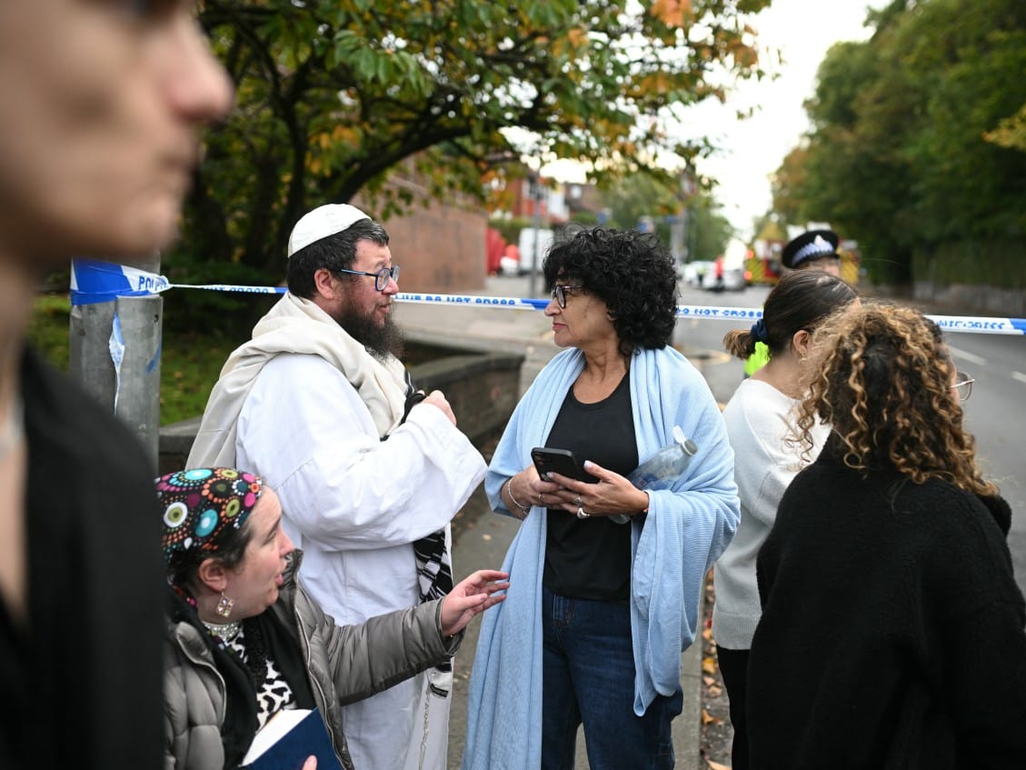 Members of the local Jewish community wait at a police cordon near Heaton Park Hebrew Congregation synagogue in Crumpsall, north Manchester, 