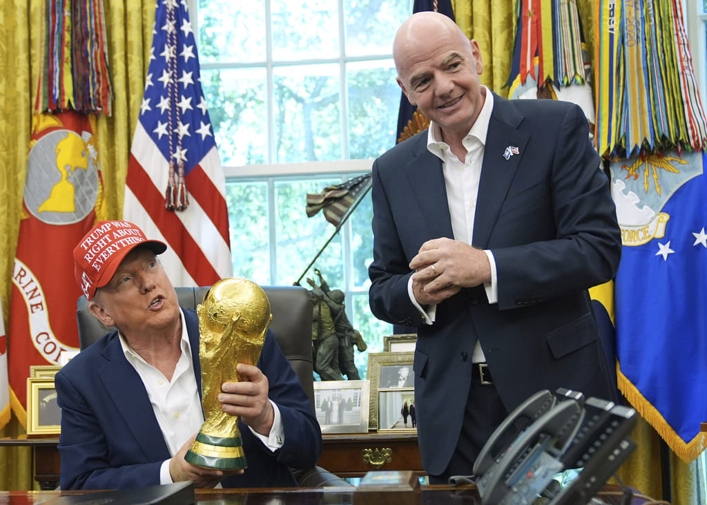 President Donald Trump holds the FIFA World Cup Winners Trophy as FIFA President Gianni Infantino looks on during an announcement in the Oval Office of the White House, Aug. 22, 2025, in Washington.
