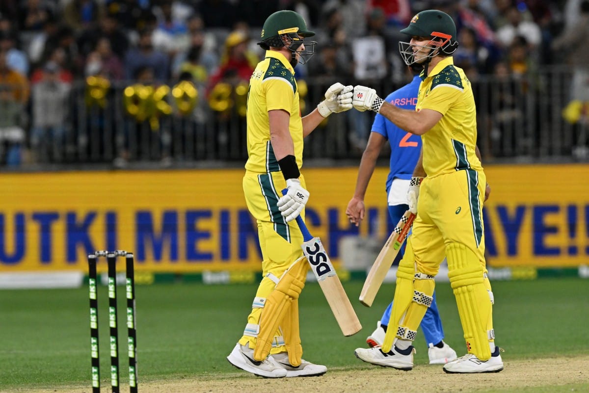 Australia's Matt Renshaw (L) and Mitchell Marsh exchange bump gloves during the first one-day international cricket match between Australia and India in Perth on October 19, 2025.