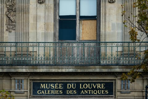 The window of the Louvre Museum is seen with the glasses covered after the thieves broke them to get in and steal priceless jewels.