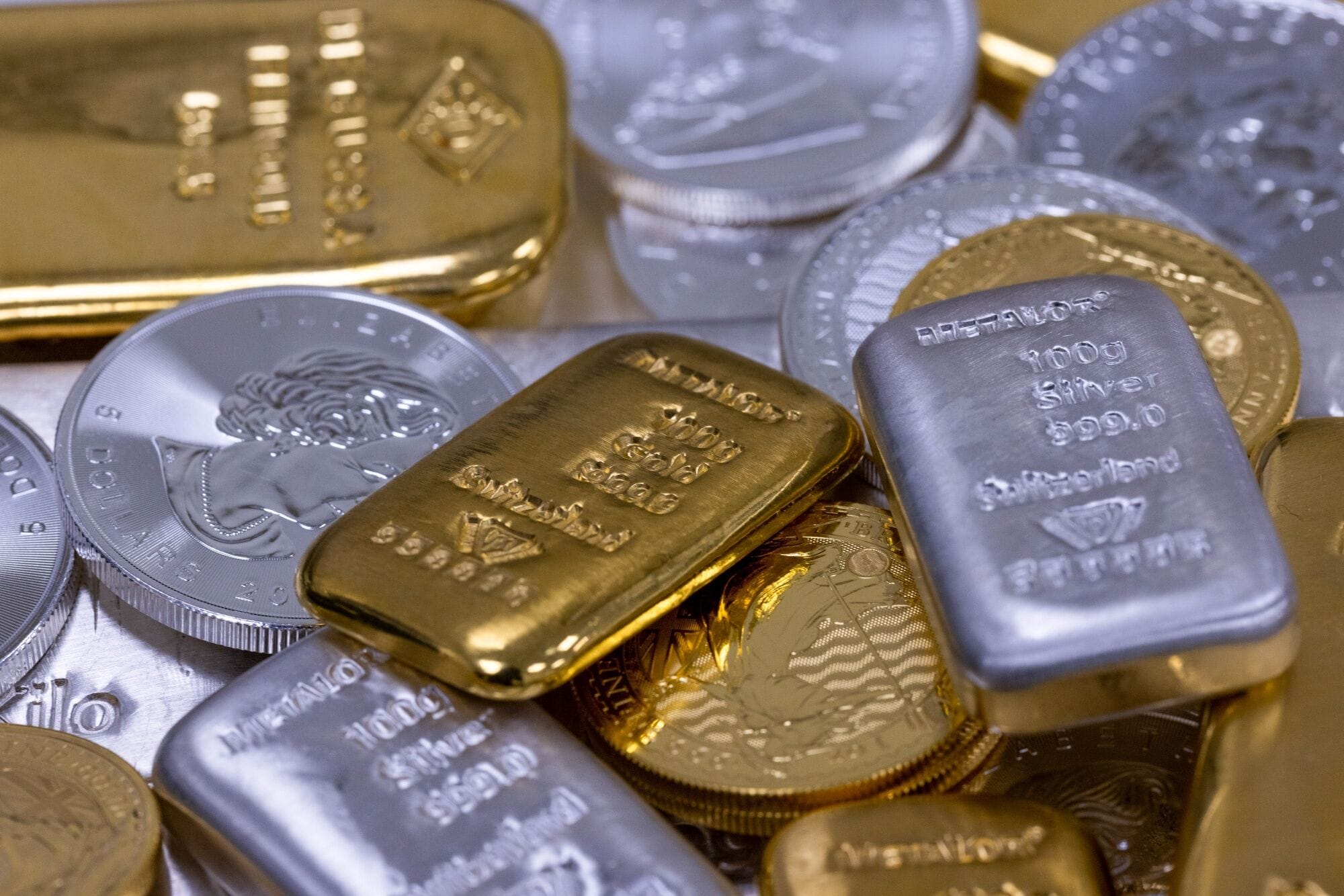 Gold bars placed beside stock market charts, symbolising safe-haven investments during periods of market volatility.