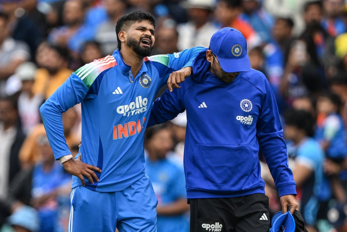 India's Shreyas Iyer (L) reacts in pain after falling on the ground while taking a catch to dismiss Australia's Alex Carey during the third ODI at the Sydney Cricket Ground in Sydney on October 25, 2025.