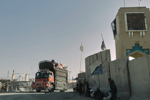 People wait near the closed gate at the Spin Boldak border crossing with Pakistan, after the border was shut for nearly two weeks following clashes between Afghan and Pakistani forces, in Kandahar province, Afghanistan on October 23, 2025.  
