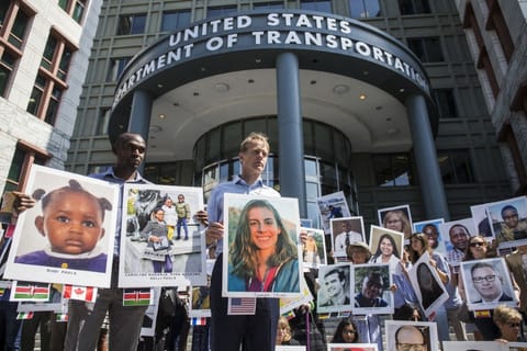 People hold signs during a vigil for victims of the Ethiopian Airlines Flight ET302 crash on September 10, 2019 in Washington, DC. 
