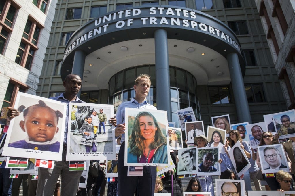 People hold signs during a vigil for victims of the Ethiopian Airlines Flight ET302 crash on September 10, 2019 in Washington, DC.