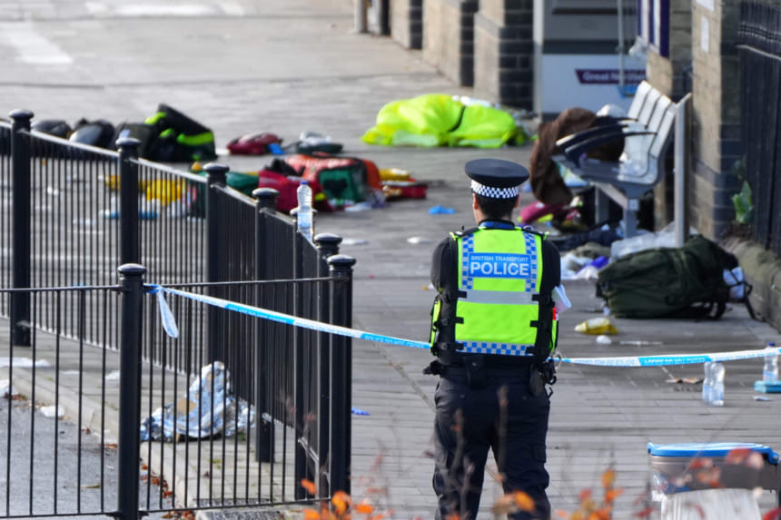 A police officer watches the area where travellers left their belongings after a mass stabbing on a London-bound train in Huntingdon, England, Sunday, Nov. 2, 2025.