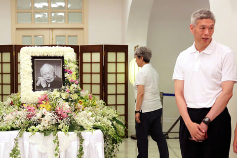 In this March 24, 2015, file photo, Prime Minister Lee Hsien Loong's brother, Lee Hsien Yang, right, receives friends and family members paying their respects to the late Lee Kuan Yew during a private family wake at the Istana or Presidential Palace in Singapore. 
