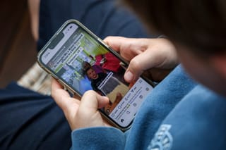 This photo taken on October 24, 2025 shows a 14-year-old boy posing at his home near Gosford as he looks at the Instagram app on his mobile phone.