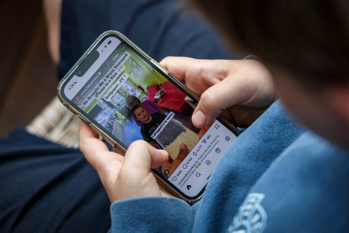 This photo taken on October 24, 2025 shows a 14-year-old boy posing at his home near Gosford as he looks at the Instagram app on his mobile phone.