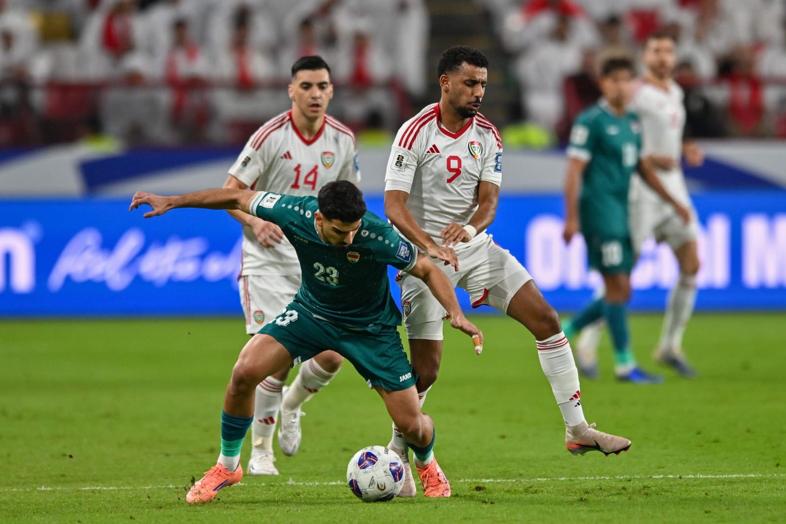 Iraqi's Merchas Ghazi (centre) is challenged by Harib Abdalla (right) and Nicolas Gimenez of the UAE during the 2026 World Cup play off first leg match in Abu Dhabi.