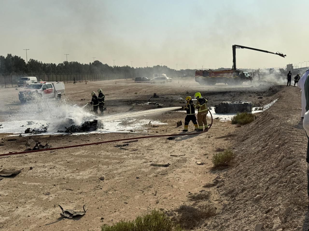 Firefighters and emergency vehicles at the site of the crash