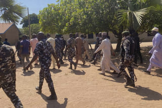 Police and government officials walk past St. Mary's Catholic Primary and Secondary School where gunmen on Friday abducted children and staff in Papiri community, Nigeria. File photo taken on Tuesday, Nov.25, 2025. 