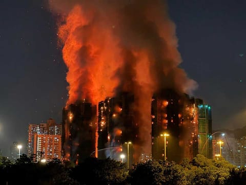 Thick smoke and flames rise as a major fire engulfs several apartment blocks at the Wang Fuk Court residential estate in Hong Kong's Tai Po district on November 26, 2025.