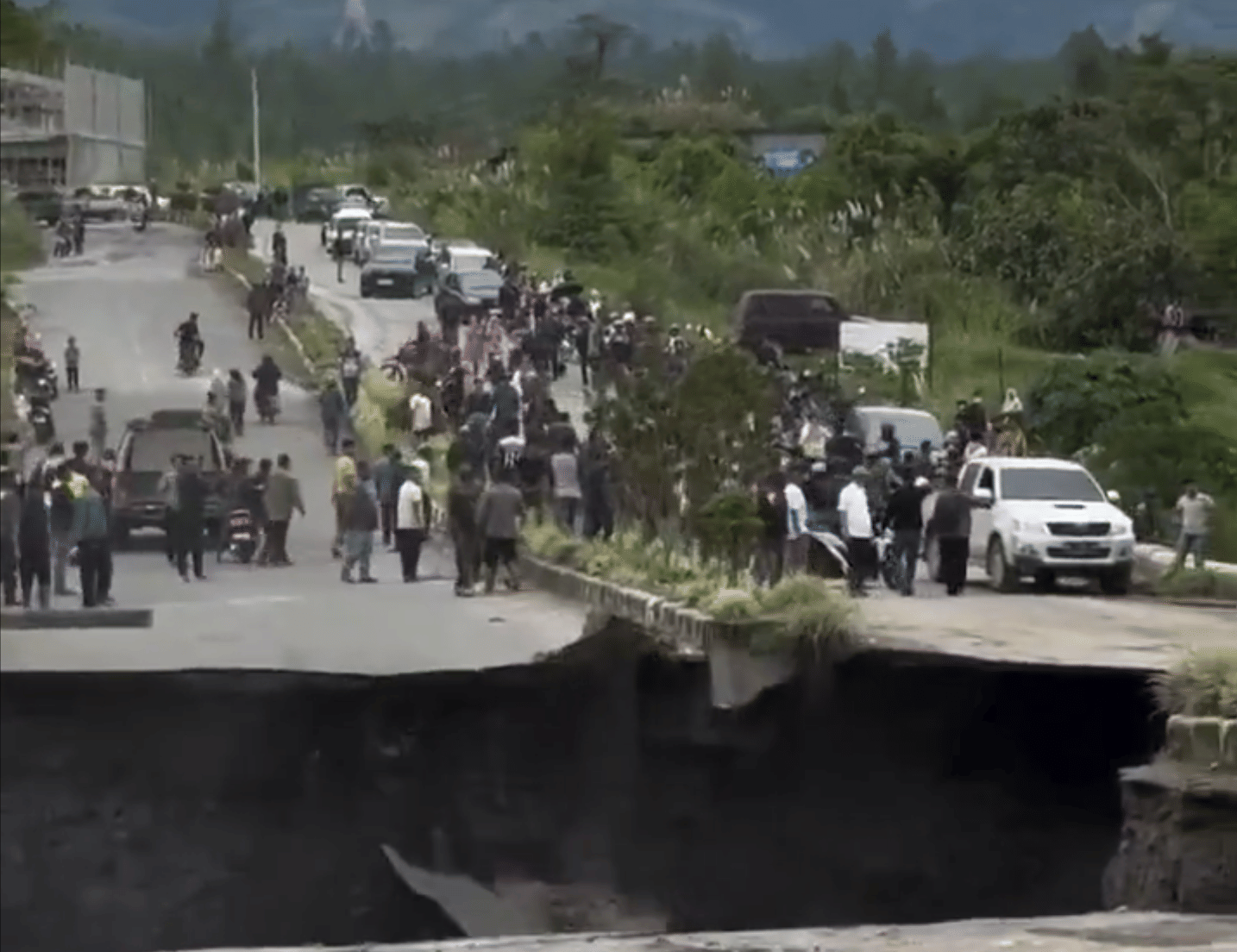 The video captured the incident showing the yawning gap on the road as chunks of asphalt and earth collapsed while people looked on during one of Southeast Asia's most devastating natural disasters.