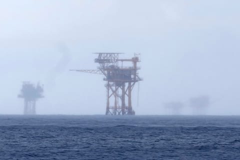 FILE - Oil platforms are visible through the haze near the Flower Garden Banks National Marine Sanctuary in the Gulf of Mexico, off the coast of Galveston, Texas, Saturday, Sept. 16, 2023. 