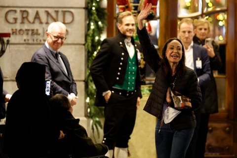 Nobel peace laureate Maria Corina Machado (R) waves to supporters gathered outside the Grand Hotel in Oslo, Norway, in the early hours of December 11, 2025.