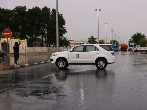 A Sharjah City Municipality patrol comes to the aid of residents in the rain.