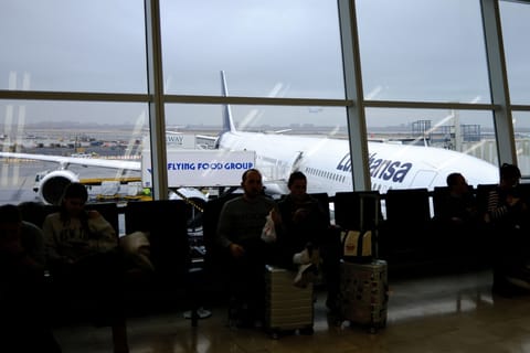 Passengers wait to board a flight at JFK International Airport in New York on December 23, 2025.