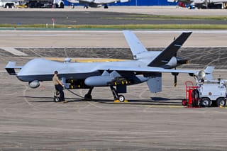 A US Air Force personnel prepares an MQ-9 Reaper drone for a mission on the tarmac at Rafael Hernandez Airport in Aguadilla, Puerto Rico, on December 27, 2025.