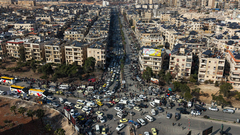 An aerial view shows Syrian residents in vehicles, queueing to flee from Sheikh Maqsoud and Achrafieh neighbourhoods after clashes broke out on Tuesday between Syrian government forces and Kurdish fighters in a contested area of the northern city of Aleppo, Syria, Wednesday, Jan. 7, 2026. 