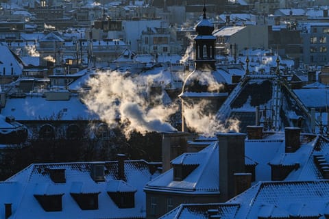 Smoke comes out of the chimneys from the rooftops of houses in central Prague during sunrise on January 11, 2026, as the temperatures dropped to minus 11 degrees Celsius in the Czech capital.