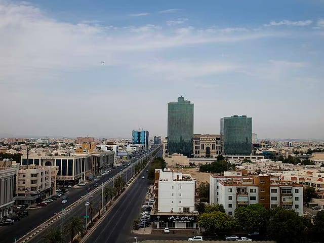 Residential and commercial properties sit on the city skyline beside a highway in Jeddah, Saudi Arabia.