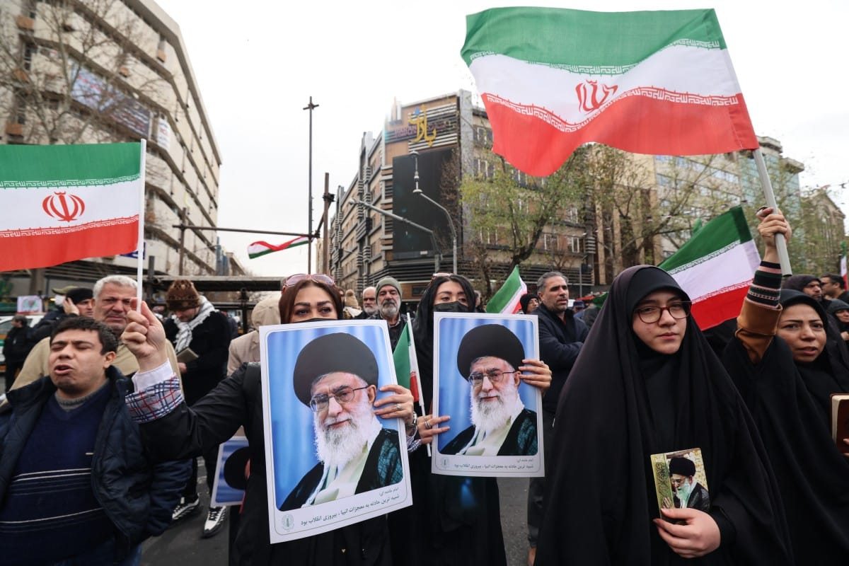 Iranian women hold portraits of Iran’s Supreme Leader Ayatollah Ali Khamenei during the funerals of security forces personnel killed in recent protests in Tehran on January 14, 2026.