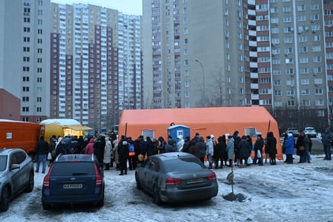 Local residents queue to receive hot meal distributed by volunteers of the US-based food charity World Central Kitchen in a residential area of Kyiv that has been left without electricity and water due to recent Russian strikes battering the energy sector on January 22, 2026, amid the Russian invasion of Ukraine.