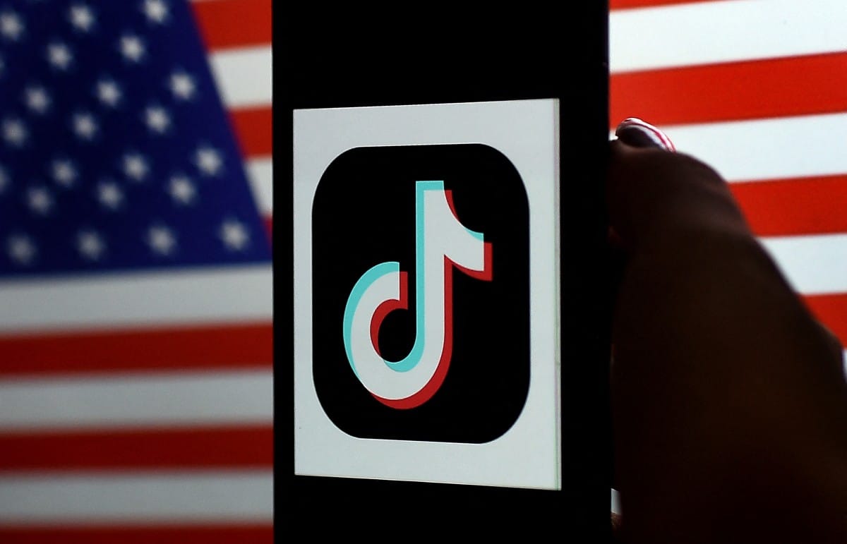 Photo illustration shows the TikTok logo displayed on the screen of an iPhone on a US flag background, taken on August 3, 2020 in Arlington, Virginia.