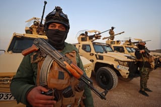 Members of the Popular Mobilization Forces stand guard at a military base near the Iraqi-Syrian border in Al Qaim, west of Iraq on January 23, 2026.