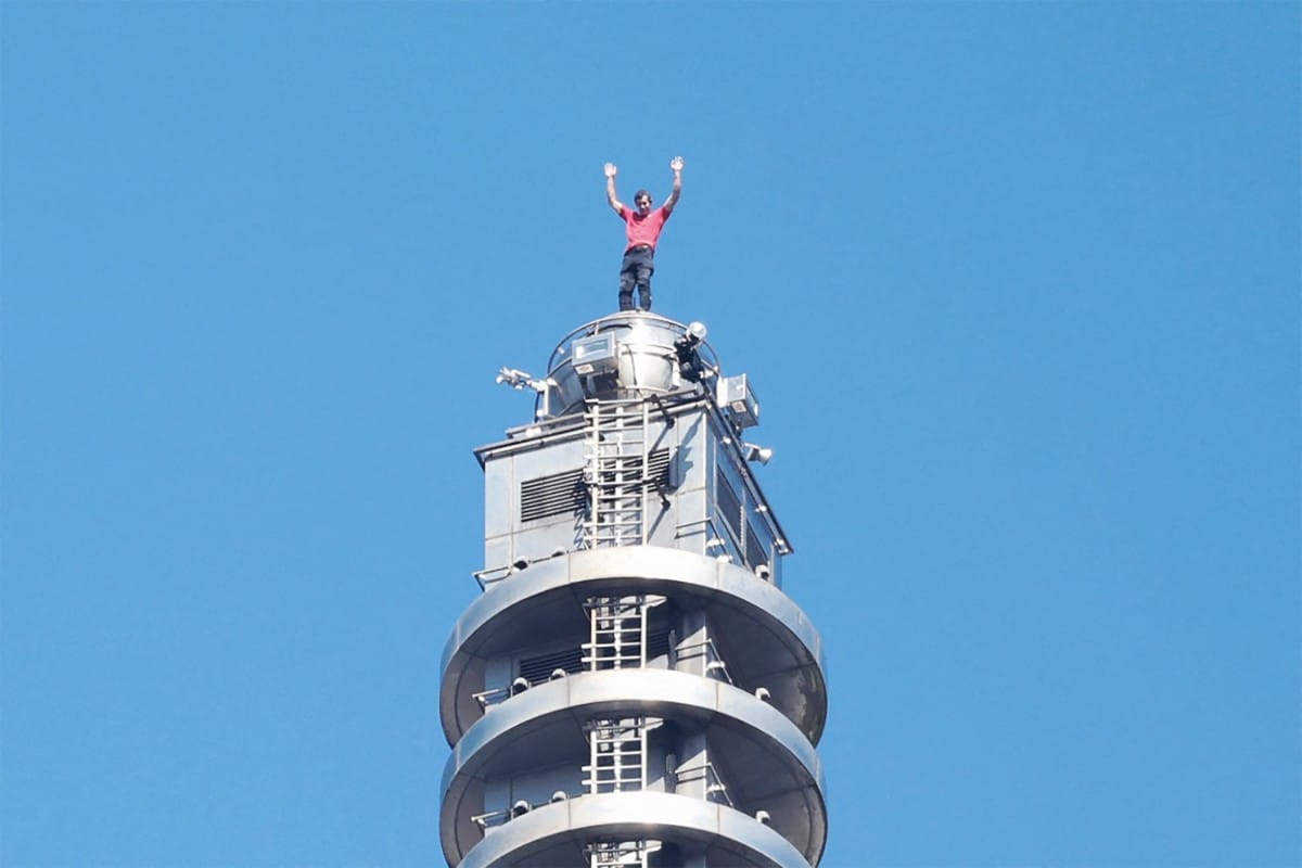 US rock climber Alex Honnold raises his arms from the top of the Taipei 101 building after he successfully free soloed the landmark skyscraper without ropes or safety gear in Taipei on January 25, 2026.