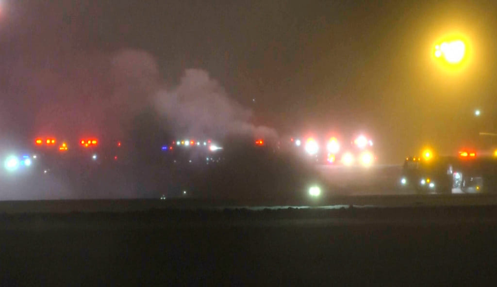 This image taken from video provided by WABI television, emergency services work on a scene of the Bombardier Challenger 600 crash at the Bangor Airport in Maine, late Sunday, Jan. 25, 2026. (WABI via AP)