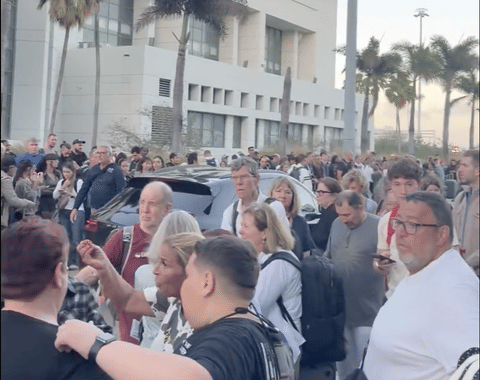 Crowds gather outdoors at the Miami International Airport amid ongoing travel disruptions due to bad weather.
