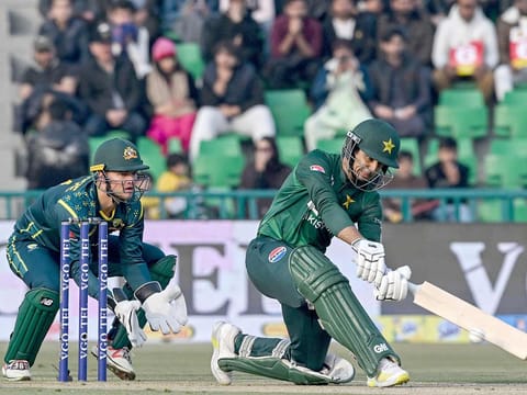 Pakistan's Saim Ayub (R) plays a shot as Australia's wicketkeeper Josh Philippe watches during the first T20I at the Gaddafi Stadium in Lahore on January 29, 2026. 