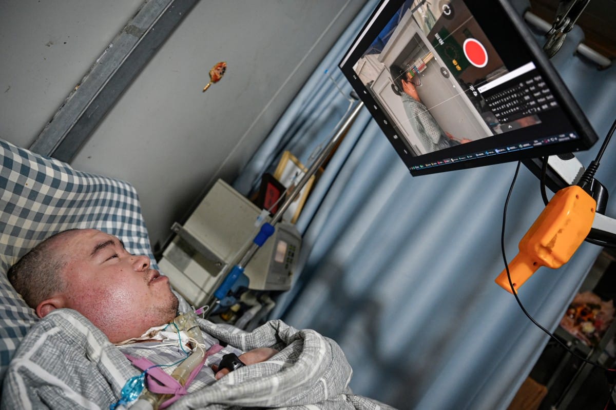 Li Xia, who has Duchenne muscular dystrophy, is guiding his mother through the circuit operation via a video monitoring app from his bed in southwestern China's Chongqing municipality.