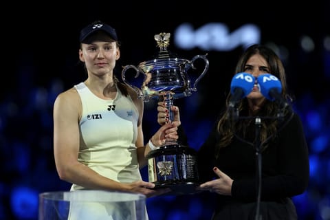 Kazakhstan's Elena Rybakina receives trophy after her victory against Belarus' Aryna Sabalenka in the women's singles final match on day fourteen of the Australian Open tennis tournament in Melbourne on January 31, 2026.